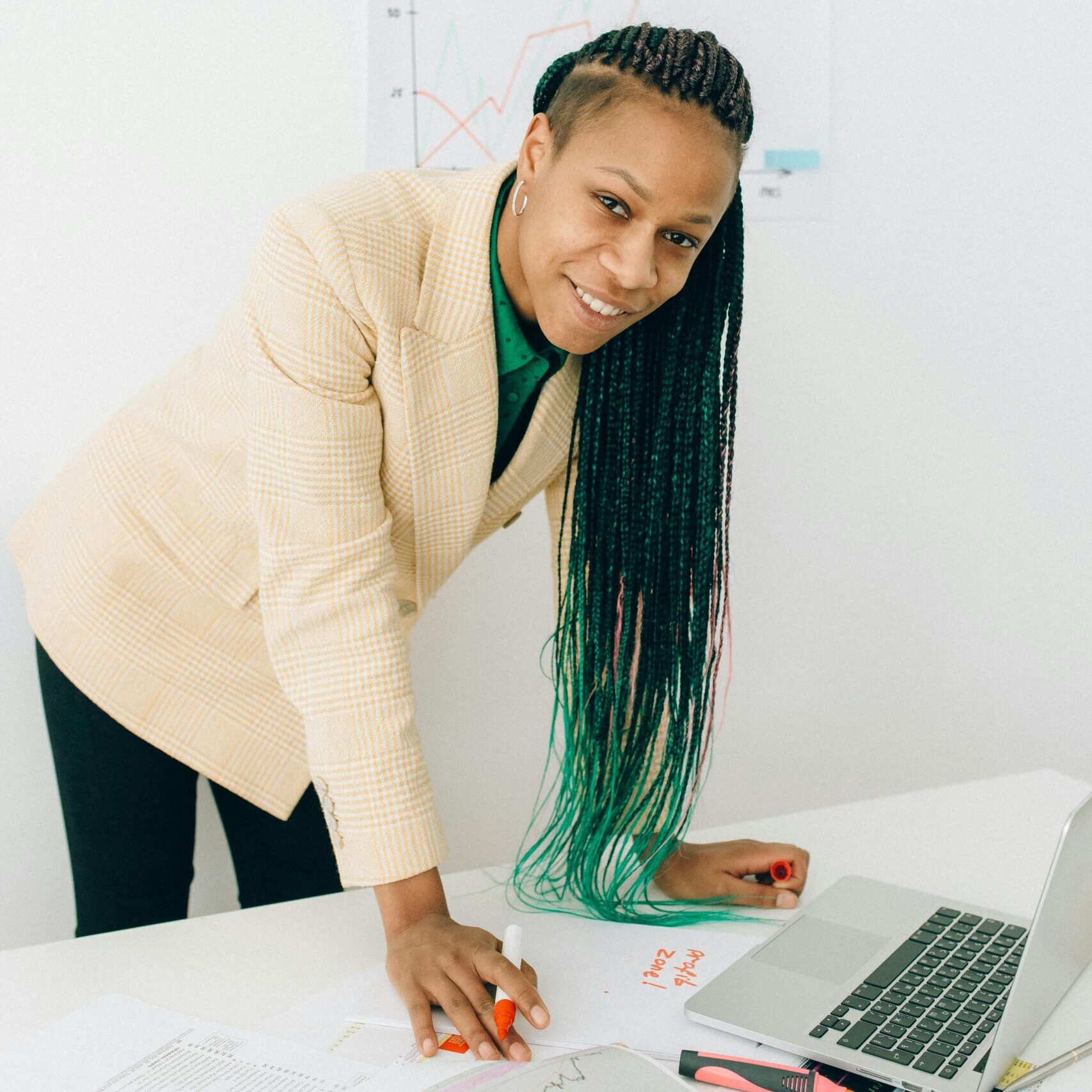 Professional woman analyzing financial charts at a desk with a laptop.