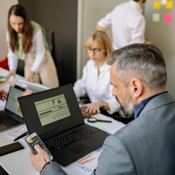 Corporate team working together with technology in a modern office setting, promoting collaboration and productivity.